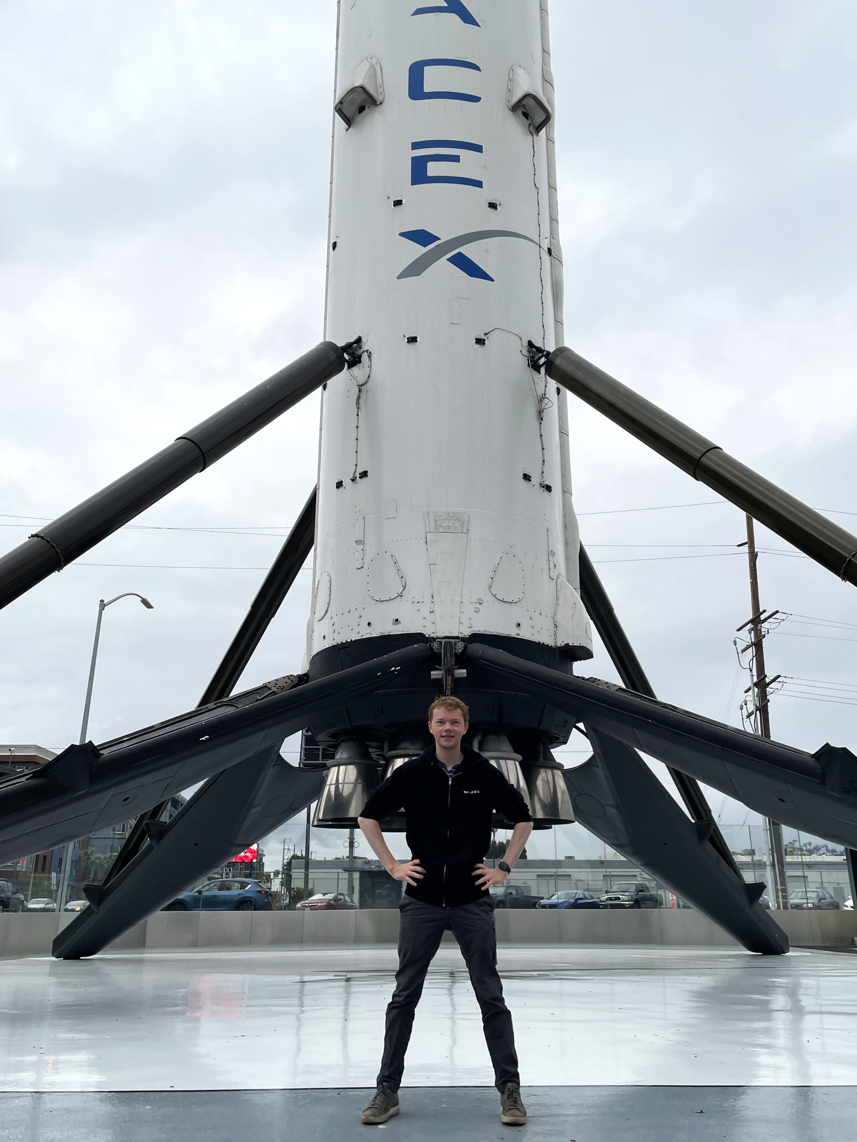 Rowan Jansens standing in front of SpaceX falcon-9 rocket